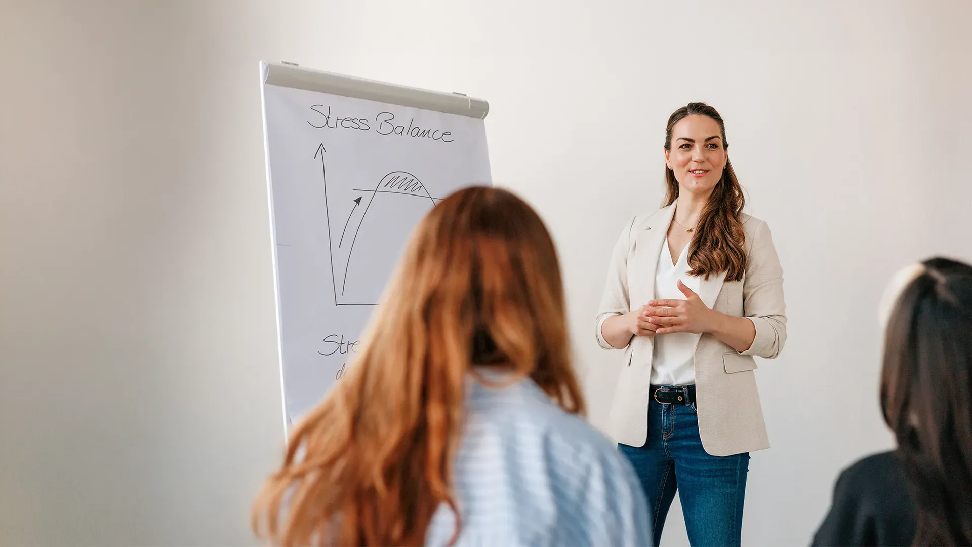 Nadin Förster zeichnet vor einem Team das Modell der Stress Balance auf ein Flipchart